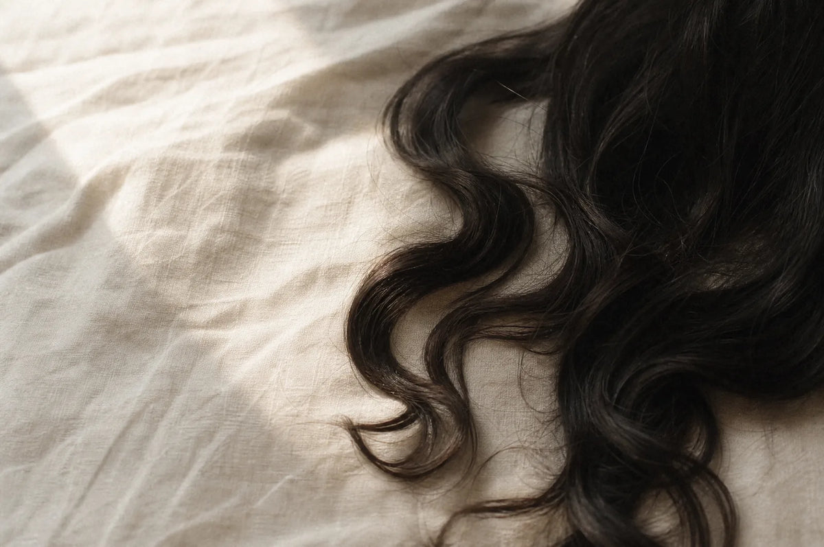 AI-generated illustration of soft waves through dark hair on linen.